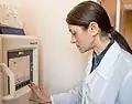 A laboratory worker reviews results displayed on the screen of the automated analyzer.