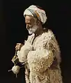 A man from Ramallah spinning wool. Hand tinted photograph from 1919, restored (American Colony Collection)