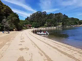 Visitors land on a sandy embayed beach at Sacramento Landing in Tomales Bay, California.