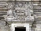 Statue of Batara Kala with horns and fangs above the door of a temple